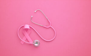 Pink stethoscope and pink breast cancer awareness ribbon on pink background. Horizontal composition with copy space. Breast cancer awareness month concept.