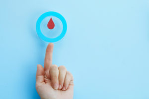 World diabetes day awareness. Woman hand with a blue circle with blood drop, symbol of the diabetes.