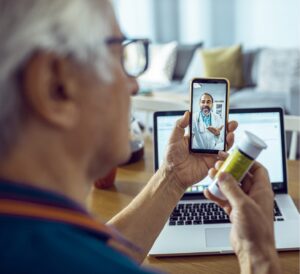 Elderly man discussing prescription with physician on telehealth call