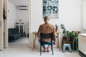 Back view of a man sitting in his home office
