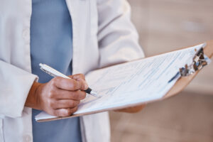 Doctor, woman hand and clipboard with pen and consultant contract for insurance document. Hospital, clinic and healthcare worker with writing and paperwork for report