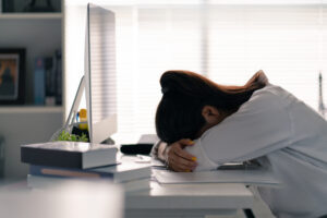 Student laying her head on the table, she was tired of working at a computer.