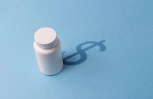 Plastic Bottle with Tablets and a shadow in the Dollar Symbol. The concept of expensive Pharmaceutical preparations and Overpriced medicine prices.
