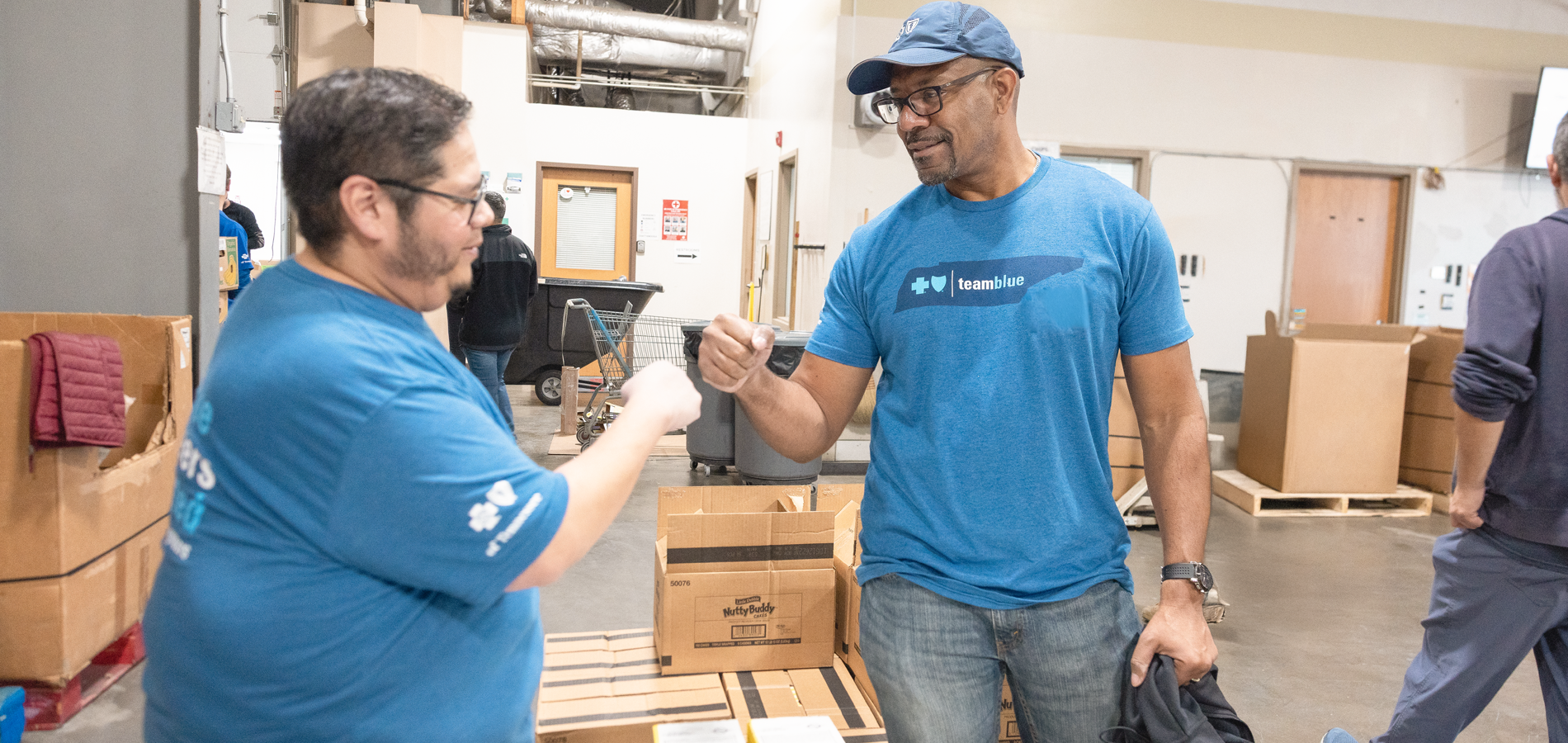 TeamBlue volunteers fist bumping each other